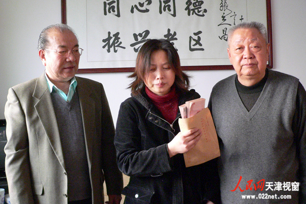 天津市老促会会长滑兵来（右）、副会长李亚平（左）代表市老促会将两万元现金交到病人母亲兰永红（中）手中
