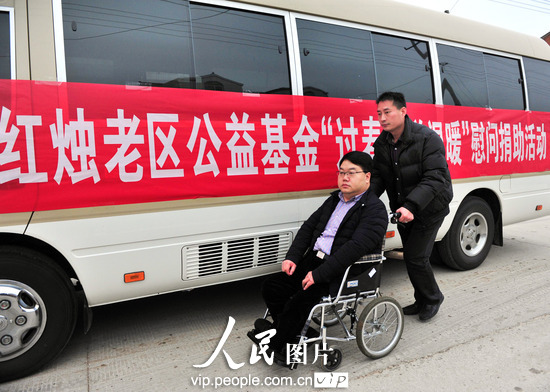 2月3日，安徽定远县，坐在轮椅上的冀盛华从爱心车边走过。